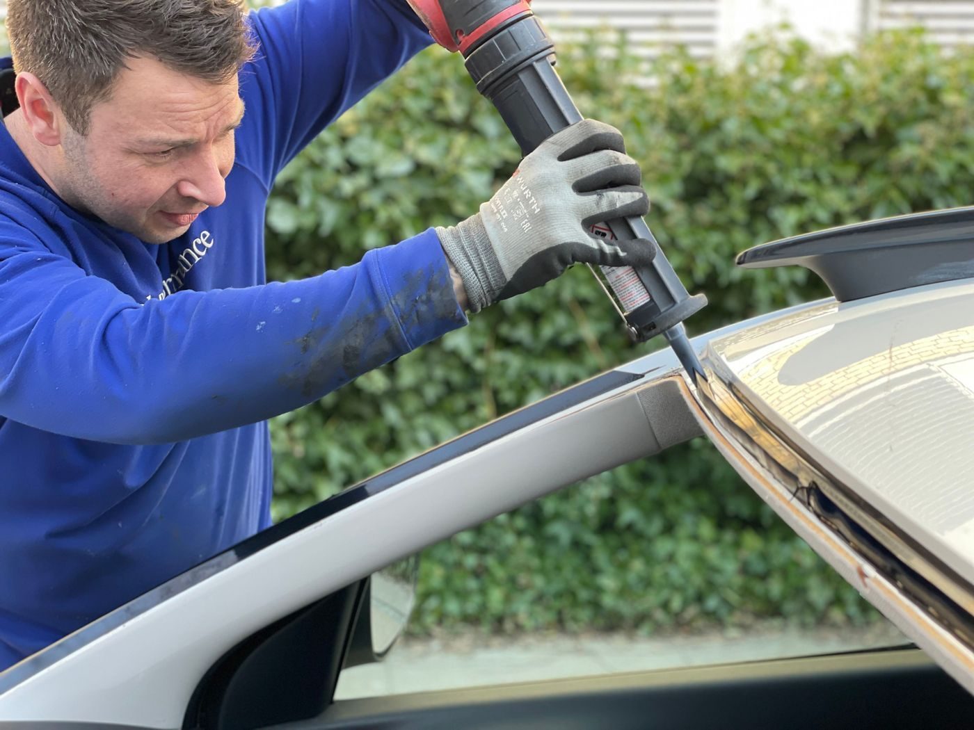 Technicien appliquant la colle de montage lors du remplacement d’un pare-brise